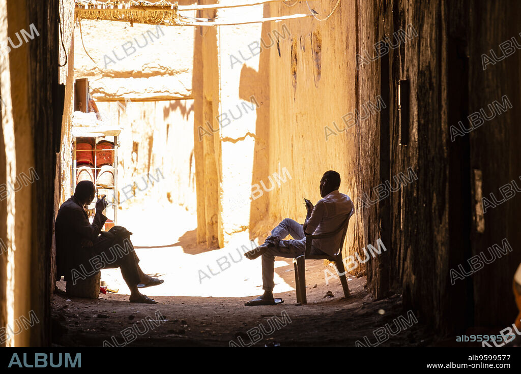 two men in the shade, ksar of Tamegroute, Draa Valley, Morocco, Africa.
