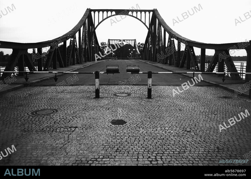 Berlin-Wannsee, Glienicker Brücke / Brücke der Einheit. (Verbindung zwischen Potsdam u. Glienicke 1831-34 erbaut nach einem Entwurf von K.F. Schinkel, 1906 Neubau, 1945-50 Wiederaufbau nach Kriegszerstörung). Ansicht mit Schlagbaum. Foto, 1978.