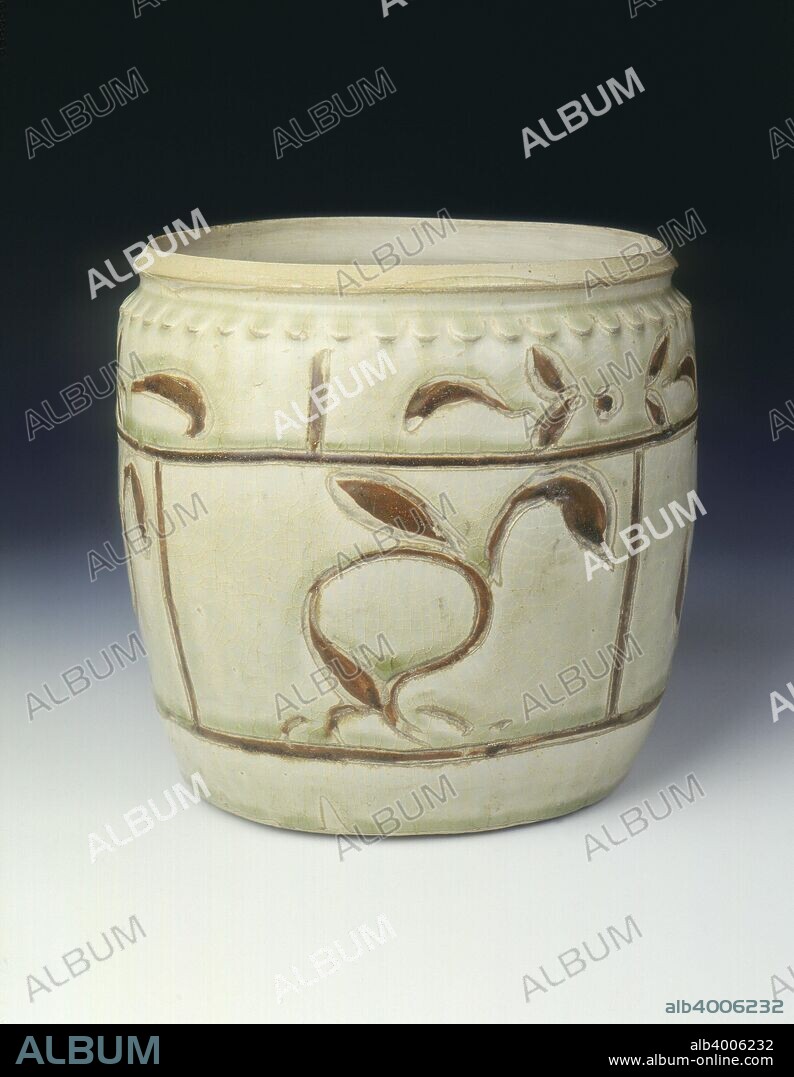 Celadon jar with floral decoration in brown slip, Thanh-hoa type, Ly dynasty, Vietnam, 12th century. A large cylindrical jar decorated on the exterior with a single band of lotus petals in relief round the mouth under the thin celadon glaze, and brown-slip outlined panels with stylized birds and flowers in relief and painted with a brown slip, the remainder under a celadon glaze. The interior is undecorated and unglazed.