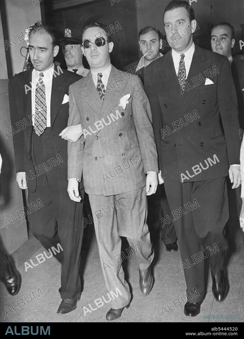 Dixie Pleads Guilty -- J. Richard (Dixie) Davis (in dark glasses), disbarred attorney, is shown here as he entered court in New York Aug. 2, to plead guilty to charges of conspiracy and contriving a lottery. Davis was a co-defendant with James J. Hines, Tammany leader, in a policy racket indictment. October 11, 1938. (Photo by Associated Press Photo).