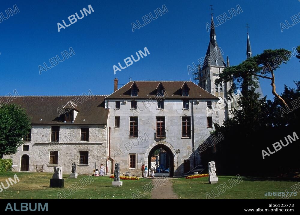 Dourdan (Dép.Essonne, Ile de France, Frankreich), Burg / Château (erbaut um 1220/1222 unter König Philipp II. August; von 1690 bis 1852 Gefängnis).-Teilansicht: Skulpturengarten mit Torhaus und Kirche Saint-Germainl'Auxerrois (12./14.Jh.).-Foto, undatiert.