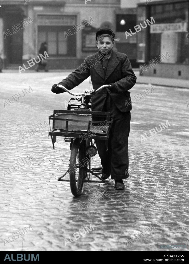 Springpojke springschas med sin paketcykel på Göran Olsgatan framför S:t Petri Kyrka i Malmö. I bakgrunden S:t Petri kyrkogata. Sydsvenskan / IBL Bildbyrå.