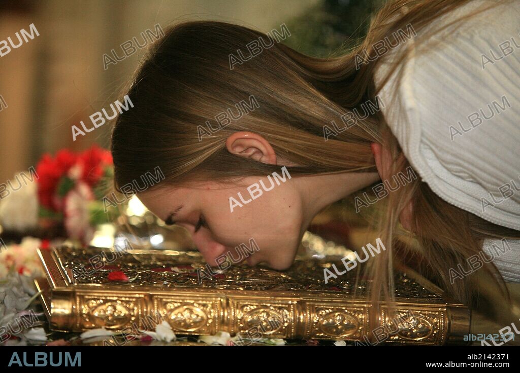 Greek orthodox devotee kissing the bible on the epitaphios on Good friday.