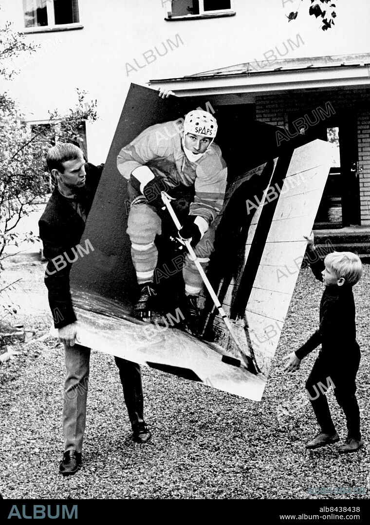 Stockholm 1967-10-04. Tumba flyttar. Sven, 36, och Pigge, 5, bär ut den stora bilden av husfadern, som hängde ovanför baren i huset, den som visar precis vem Tumba alltid varit och ännu en tid är. Sven och Pigge gillar den här bilden lika mycket båda två.. Foto: Lars Nyberg / Expressen / TT / Kod: 34. ** AFTONBLADET OUT **.