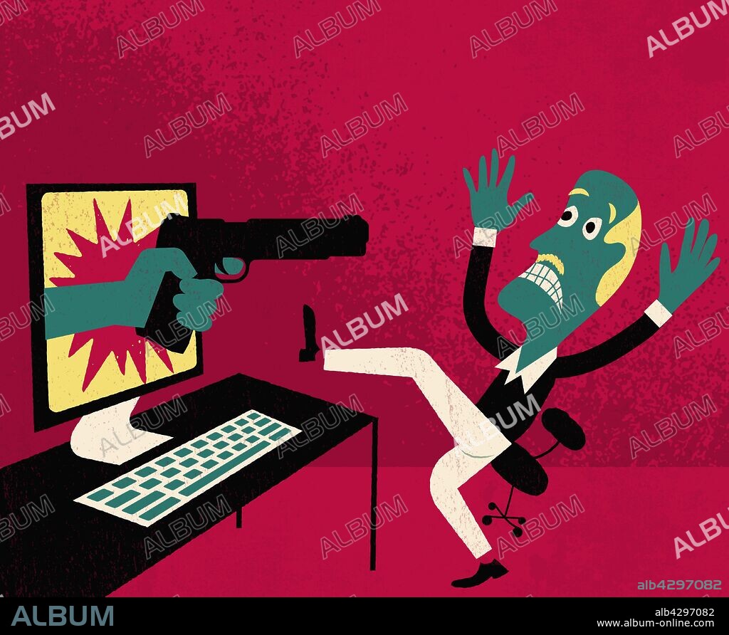 Man using computer in hold up as hand pointing gun emerges from monitor screen.