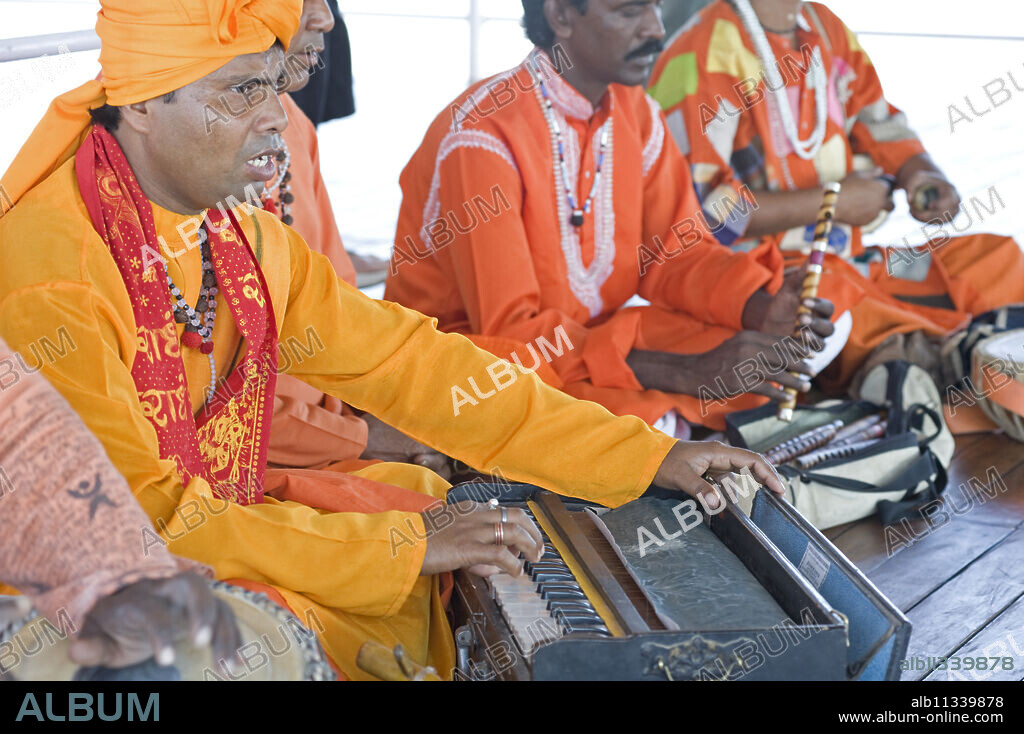 Hindu musicians singing ragas and playing ten scale Indian harmonium keyboard, tabla, pipe and hand cymbals, West Bengal, India, Asia.
