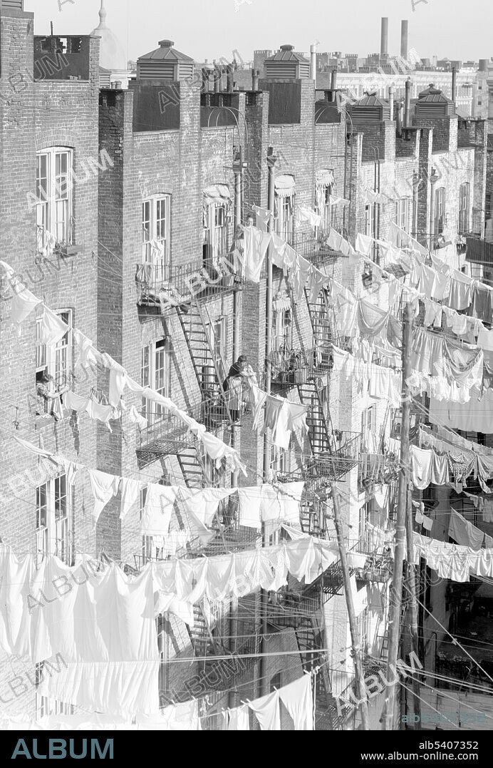 Yard of tenement, NYC. A clothes line or washing line is any type of rope, cord, or twine that has been stretched between two points, outside or indoors, above the level of the ground. Clothing that has recently been washed is hung along the line to dry, using clothes pegs or clothespins. Washing lines are attached either from a post or a wall, and are frequently located in back gardens, or on balconies. Detroit Photographic Company,  circa 1900-10 (cropped and cleaned).