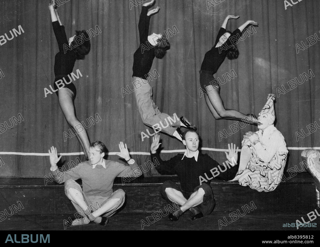 "Dodo the Clown (played by John Edmund) perches on the stage, open-mouthed with astonishment, as ballet girls, from left, Kay Smith, Pauline Menzies and Vivien Arnold leap high behind Stan Page (left) and Barry Gordon during a rehearsal of "Dodo and the Bunyip", and Australian Fantasy for children. It will open at the Arrow Theatre, Middle Park, on Saturday night for a seven-day season. "Dodo" became a favorite when he appeared before 20,000 Victorian school children in a series of concerts in the last two months. September 30, 1954.