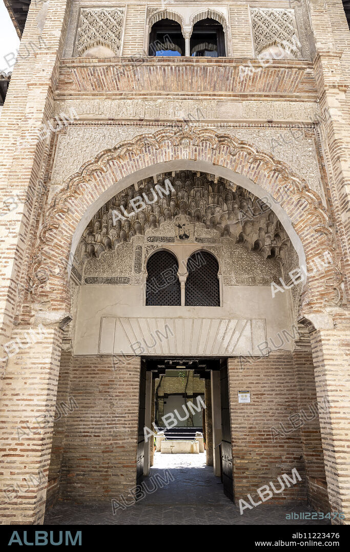 ancient funduk "Corral del Carbón" , "al-fundaq al-yadida", a pointed horseshoe arch of scalloped brick, with albanegas of atauriques carved in plaster, 14th century, Granada, Andalusia, Spain.