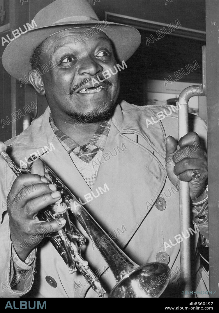 "The King". 17-stone American Negro trumpeter Rex Stewart now touring Australia with Graeme Bell's Dixieland Jazz Band, greeted Sydney with a grin when he arrived by train from Goulburn. Christened "The King" by the Bell Band Boys, Stewart is regarded as one of the five best trumpeters in the world. October 8, 1949.