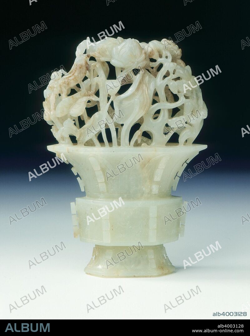 Jade gu shaped beaker with flowers and fruit, Southern Song-Yuan dynasty, China, 12th-14th century. A vase of archaic gu-hexagonal shape with peonies, peaches, lingzhi fungus and lotus sprouting from the edge round the top, all coming together at the apex with three holes for the hollowing instruments. The vase is carved out of one pebble and hollowed neatly, the body is carved with taotie masks and cicada frieze.