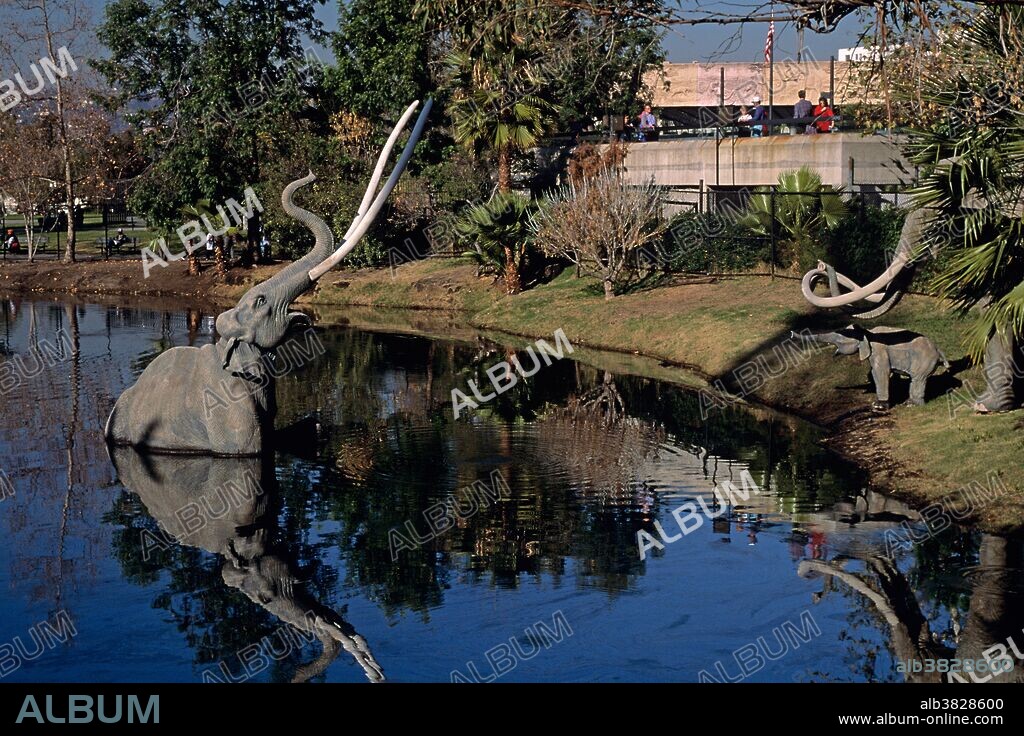 Tourists looking into a tar pit at the La Brea Tar Pit Museum on Wilshire Blvd, Los Angeles, California USA.