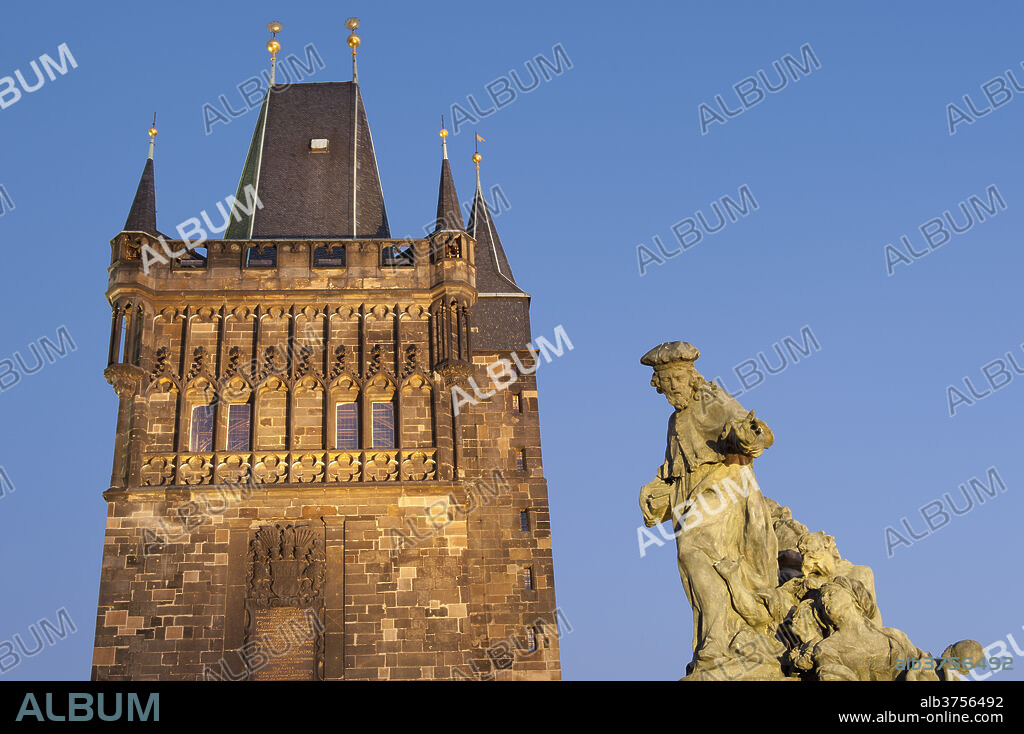 Gothic Old Town Bridge Tower and Baroque statue of St. Ivo (Bishop of Chartres) at twilight, Charles Bridge, Old Town, UNESCO World Heritage Site, Prague, Czech Republic, Europe.