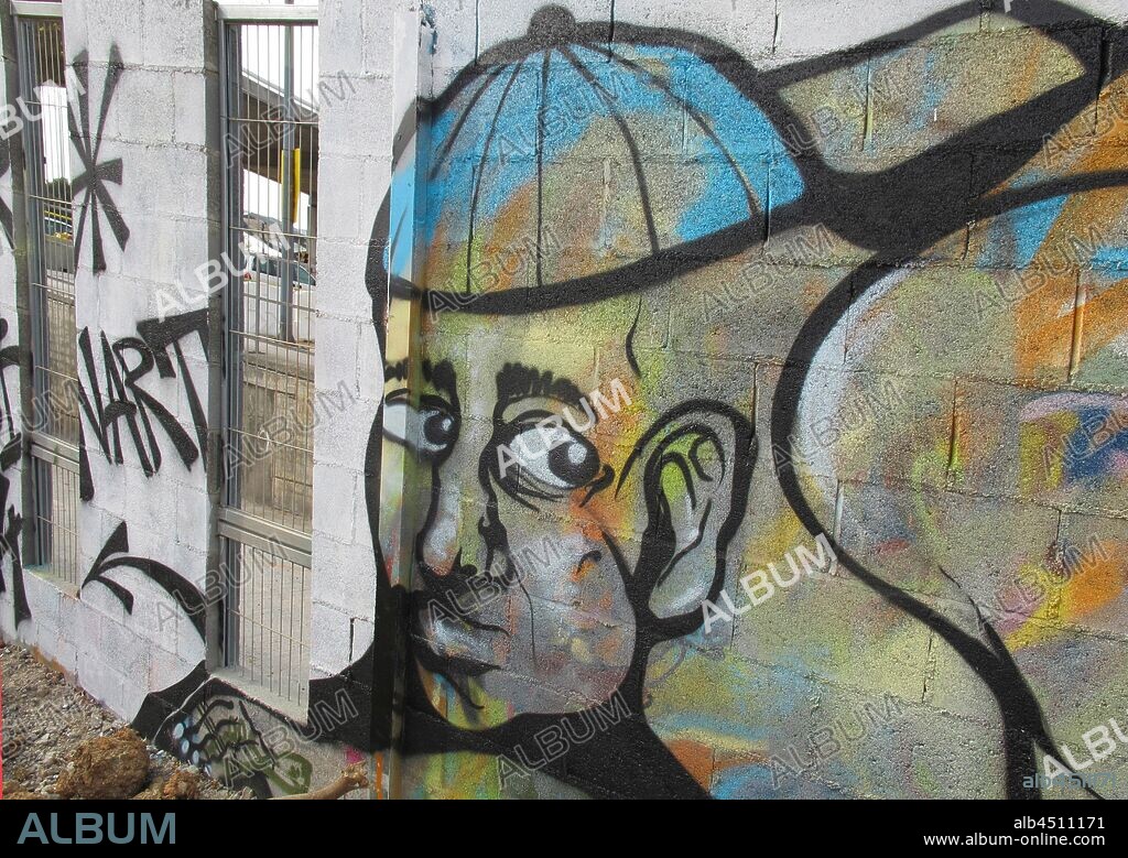 Pintura de cara de joven con gorra mirando de perfil; graffiti mural, Plaza de las Glorias; Distrito San Martin, Barcelona en 2014.