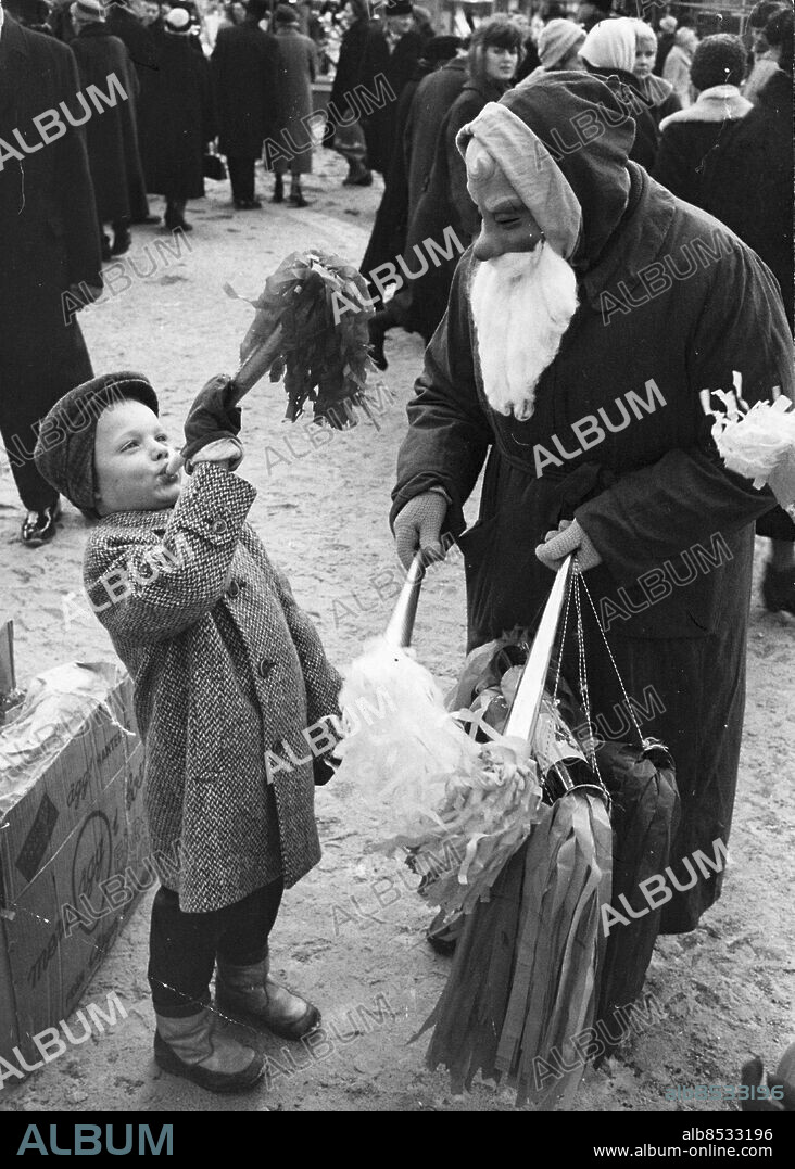 Stockholm 1959-12-13. Robert Löfgren, 6 år, blåser i en tuta som han fått av jultomten på Hötorgets julmarknad. Foto: Sven Åsberg / DN / TT / Kod: 192. ** SvD OUT **.