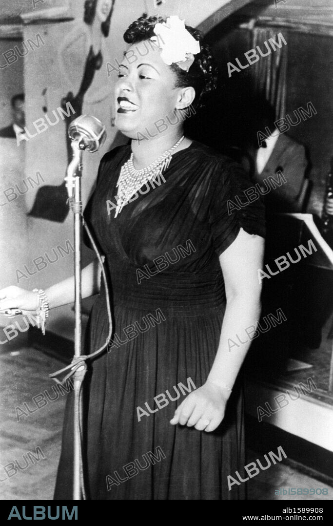 American jazz singer Billie Holiday performs with a flower in her hair at the Offbeat Club, Chicago, 1939.
