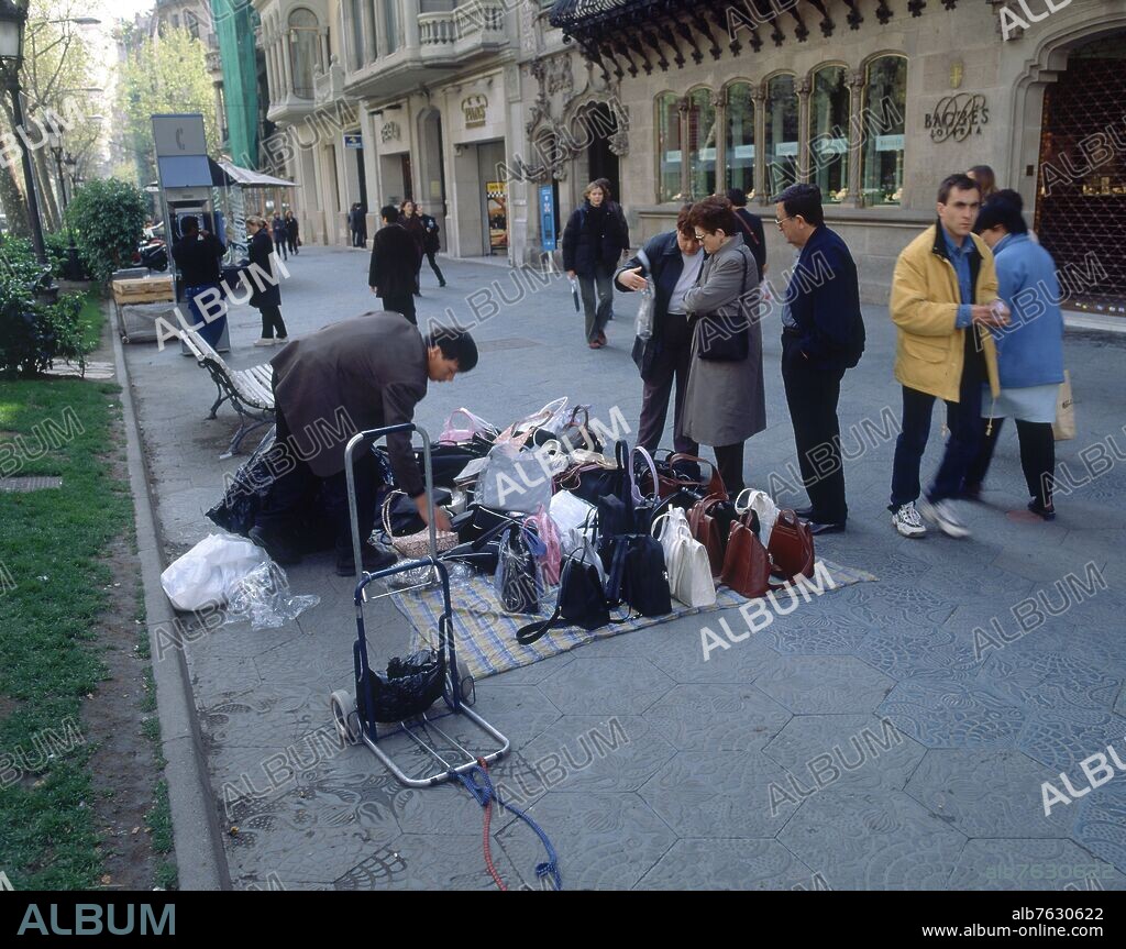VENDEDOR CALLEJERO DE BOLSOS EN EL PASEO DE GRACIA.