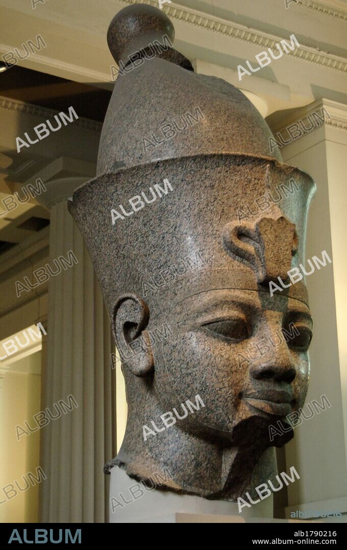 Head from monumental red granite statue of an egyptian king wearing the double crown. Probably Amenhotep III. Around 1390 BC. 18th Dynasty. New Kingdom. From the temple of Mut, Karnak,Thebes. British Museum. London. United Kingdom.