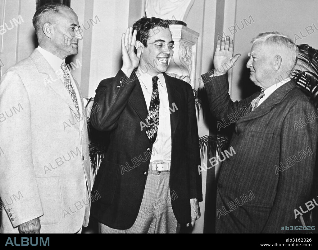 Washington, D.C.:  June 21, 1935. Vice President John Garner administers the oath for Rush Holt to take his seat in the Senate. Although Holt was elected in West Virginia last November, he had to wait until June 19th when he turned the required age of 30 to be able to take his seat in the Senate. Senator M.M. Neeley of West Virginia stands by at the left.