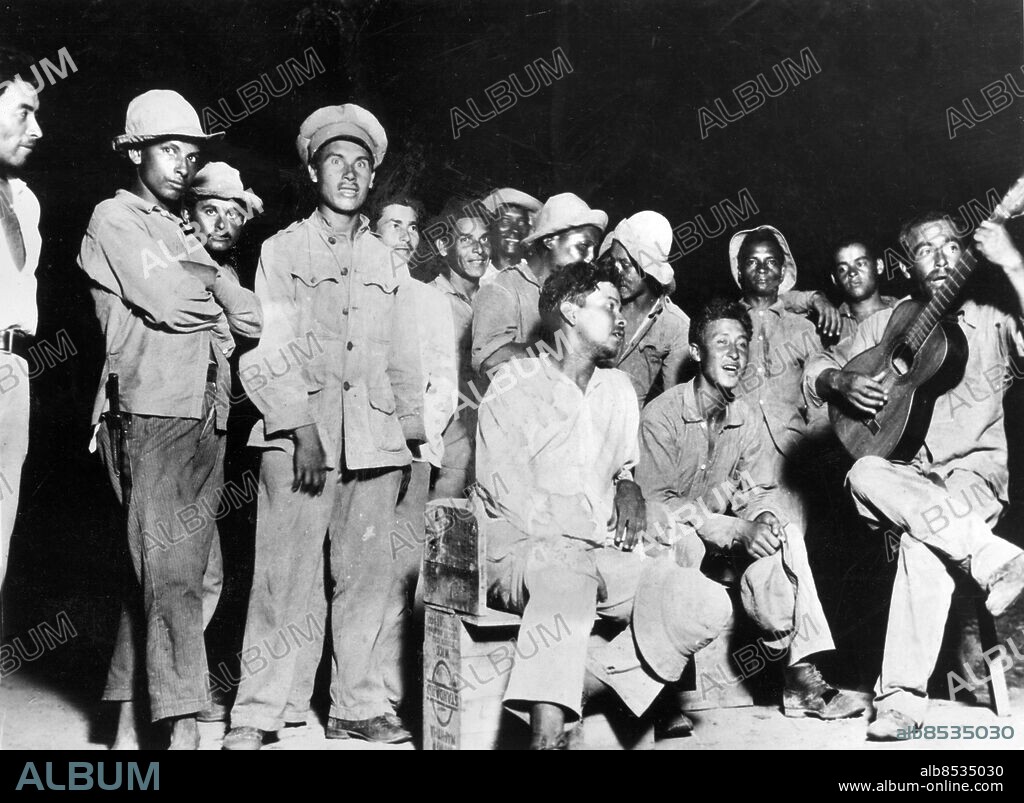 Orig. bildtext... SCENES FROM CHACO WAR Paraguayan soldiers are shown during a recreation period behind the front lines in the Chaco war between Paraguay and Bolivia. 7/13/34 Anm. Chacokriget 1932-1935 - orsakat av konflikt mellan Paraguay och Bolivia om kontrollen över Gran Chaco-regionen, som felaktigt antogs ha stora oljefyndigheter. Kriget slutade med seger för Paraguay. Gitarrer Ledighet Permission Sjunga Spela CD608 sites: BOLIVIA*;PARAGUAY;SYDAMERIKA.