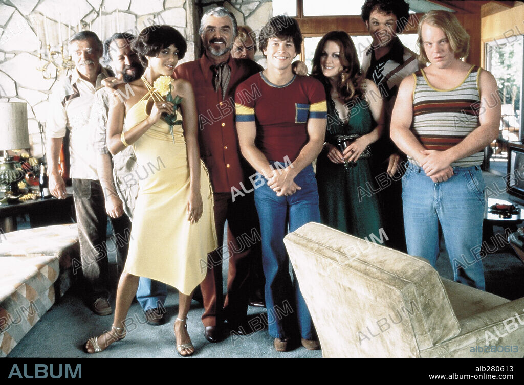 BURT REYNOLDS, DON CHEADLE, JACK WALLACE, JULIANNE MOORE, MARK WAHLBERG, NICOLE ARI PARKER, PHILIP BAKER HALL, PHILIP SEYMOUR HOFFMAN, RICKY JAY and WILLIAM H. MACY in BOOGIE NIGHTS, 1997, directed by PAUL THOMAS ANDERSON. Copyright NEW LINE CINEMA.