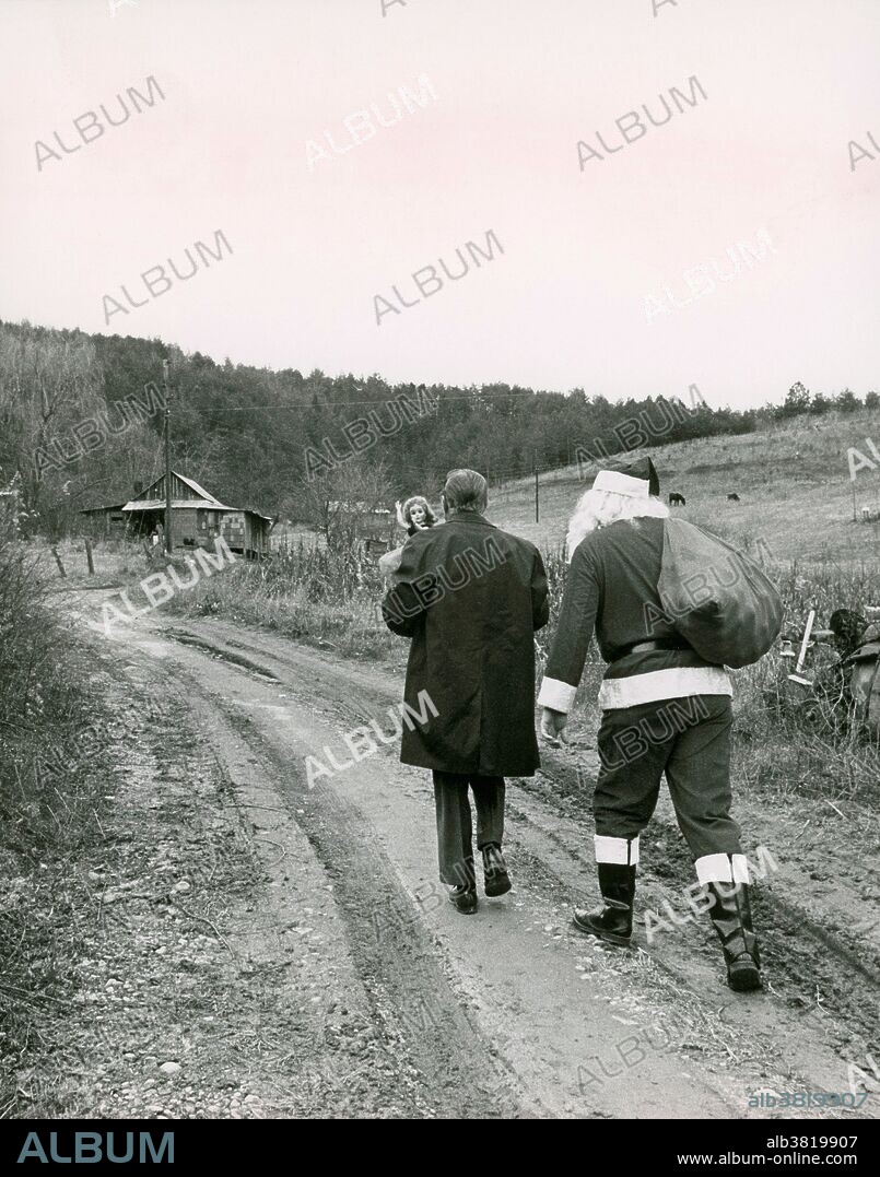 Santa Claus brings presents to children in Appalachia, thanks to the Parson of the Hills; 1965. The charity was set up to provide gifts to the children of the Appalachias. Here, the Parson and Santa come on foot, as the road was not passable for the truck.