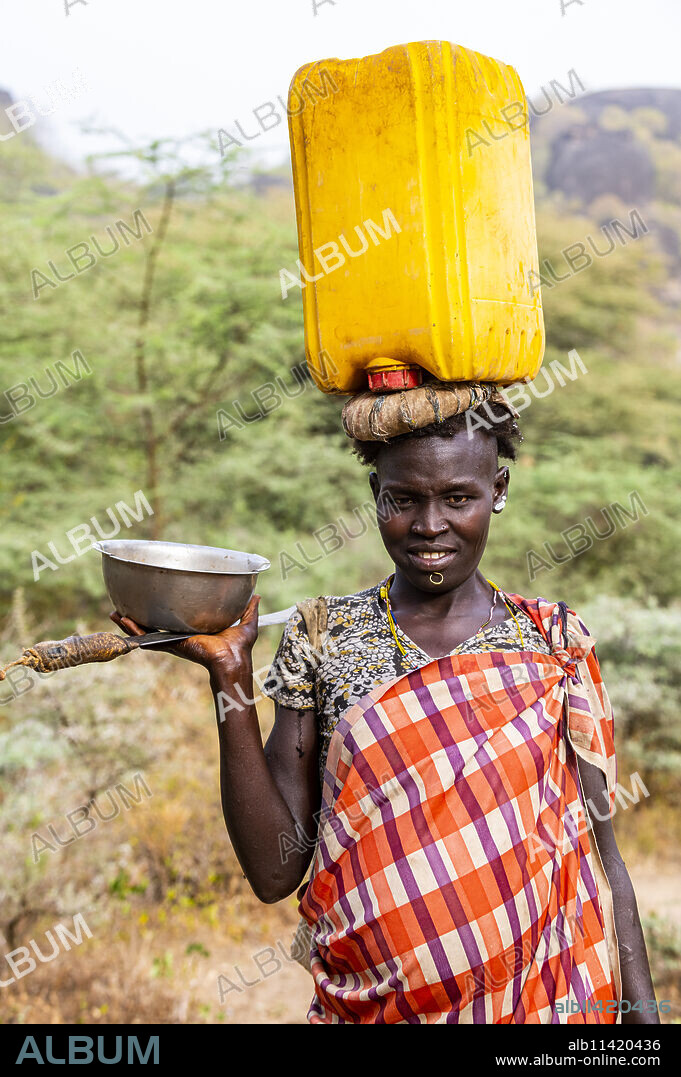 Woman with a water caniister on her head, Laarim tribe, Boya Hills, Eastern Equatoria, South Sudan, Africa.