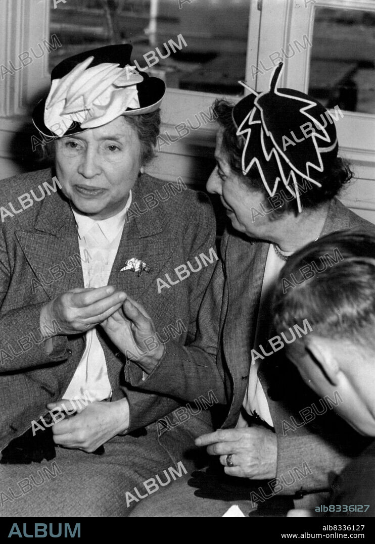 (Below, right) on her right hand her secretary Polly Thomson "describes" the scene. Helen Keller gives and at ***** he person after her arrival by flying lost from NZ. January 1, 1948.