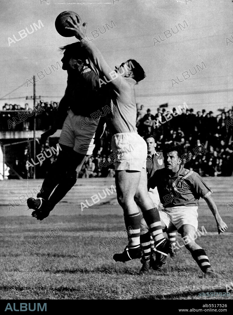 Ron Lord leaps into the air to talk the ball and save a desperate situation.NSW Goalkeeper Ron Lord, in brilliant form for NSW against the Australian Soccer team at the Sports Ground yesterday, flies in the air to take the ball from the head of Gordon Nunn. Harry Robertson looks on, awaiting the outcome of play. September 5, 1950.