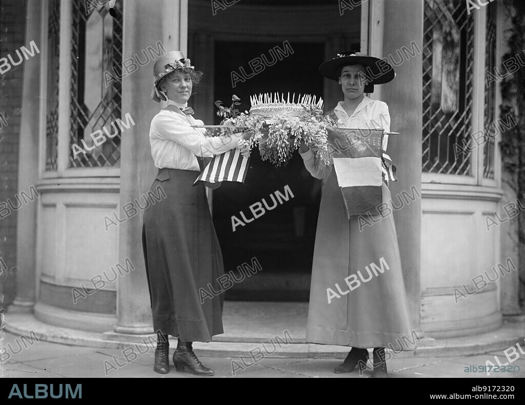 HARRIS & EWING. Woman Suffrage - Birthday Cake, 1916. Shows Gertrude Crocker (right, wearing wide-brimmed hat), holding cake with another woman, possibly her sister Ruth, in front of the Congressional Union for Woman Suffrage at 21 Madison Place, Washington, D.C. Crocker was Assistant Treasurer or Treasurer of the National Woman's Party at the time.
