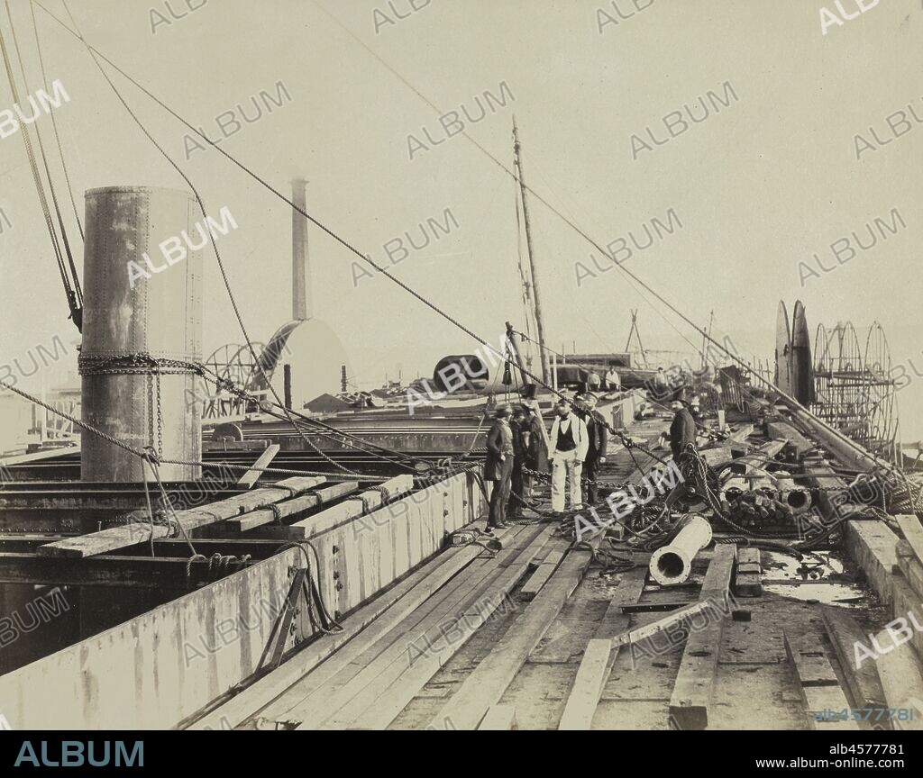 Deck Scene of the Great Eastern, 1857. A leading professional photographer of the mid-1850s, Robert Howlett is best known for his extended group of photographs documenting the construction and launching of the Great Eastern steamship. Designed by one of the greatest engineers of his time, I.K. Brunel, the Great Eastern took over four years to construct and, because of its immense size, an unprecedented three months to launch. For over forty years, the Great Eastern was the largest steamship ever constructed and it became a symbol of Great Britain's national pride and industrial supremacy. In this image, Howlett has captured the steamship's deck in the midst of construction while laborer's stand idly in the background and gentleman and engineers seem to confer in the foreground.