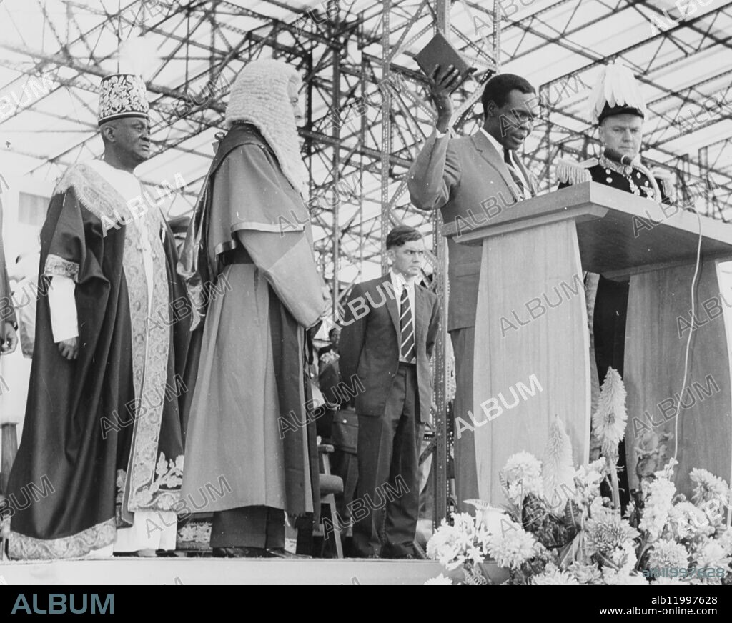 Uganda Independence Celebrations. - - First pictures have arrived from Ugada showing the country's grand-scale celebrations on her becoming independent. Never in the history of the country has there been so much frenzied excitement and enthusiasm as that shown by the people at the celebrations and ceremonies carried out throughout the land. Photo shows: Prime Minister Milton Obote swears allegiance to the Queen, as Uganda is now a full member of the Commonwealth. On his right is the Lord Chief Justice of Uganda. Uganda. 10 September 1962.