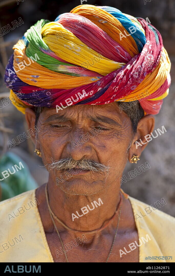 Indian man wearing traditional Rajasthani turban and gold earring in village of Nimaj, Rajasthan, Northern India.