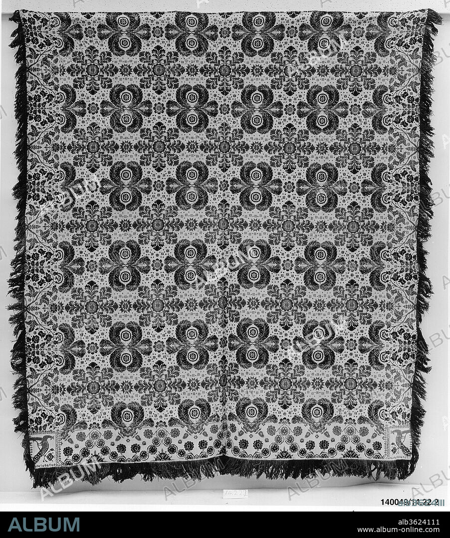 Coverlet. Culture: American. Dimensions: 98 1/2 x 89 3/4 in. (250.2 x 228 cm). Date: ca. 1840.
This coverlet is woven in two panels and seamed at the center. It has a warp of undyed and light blue cotton and a weft of dark blue, green, and red wool and undyed cotton. The central field shows feather medallions alternating with foliate medallions. The bottom border has a stylized vine motif, and the right and left borders have roses and tulips. Peacocks adorn each of the two corner blocks. Both sides of the coverlet have natural fringe, and there is attached fringe along the bottom edge.