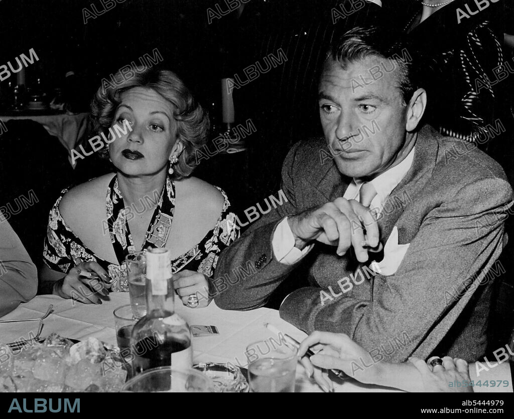 Gary Cooper, and Ann Sothern, who recently shed Robert Sterling, a only half of a party of four. The cigarette holder on the right belongs to Veronica Cooper and Coop never goes to parties without her. October 27, 1948.