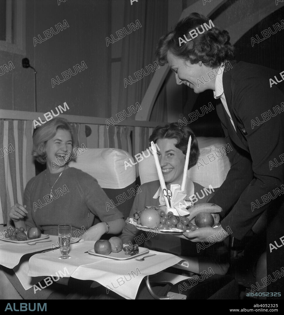 SAS stewardess serving on a flight, 1960. Scandinavian Airlines System (SAS), the flag carrier of Sweden, Norway and Denmark, was founded in 1946.