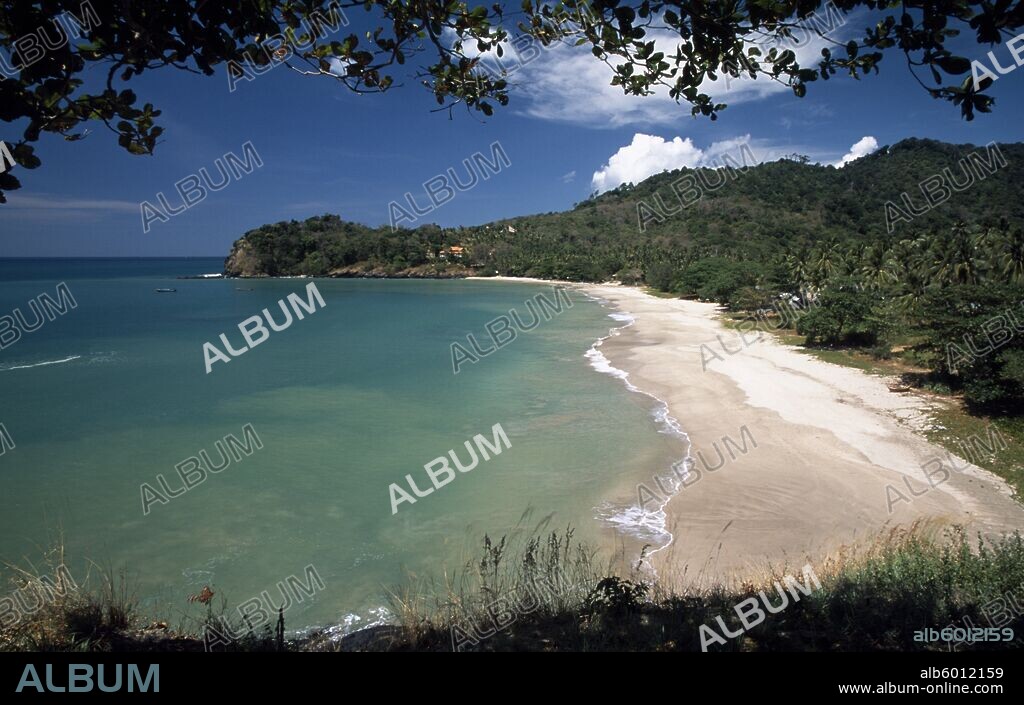 THAILAND Krabi Koh Lanta Yai Klong Jark or Waterfall Bay seen through trees with waves rolling ashore.