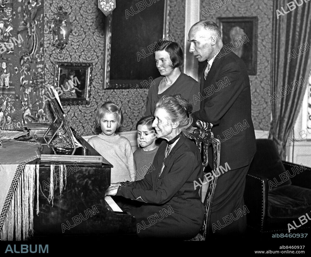 ARKIV 1934. Alice Tegnér (1864-1943), tonsättare och musiklärare. Mest känd för sina barnvisor "Bä, bä vita lamm", "Mors lilla Olle" och "Ekorrn satt i granen!".. Här tillsammans med sonen Torsten Tegnér och barnbarnen.. Alice Tegnér, composer of songs for children. Picture shows her at the piano with her son Torsten Tegnér and grandchildren.. Foto: TT / Kod 1900.