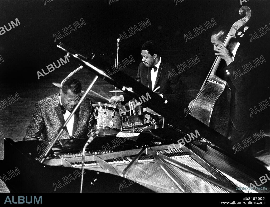 STOCKHOLM 1966-03-28. Kanadensiska pianistern och kompositören Oscar Peterson uppträder med trumslageren Louis Hahes basisten Sam Jones på konserthuset i Stockholm 28:e mars 1966.I bakgrunden basisten Sam Jones.. Foto: Jan Collsiöö / TT / Kod: 1001.