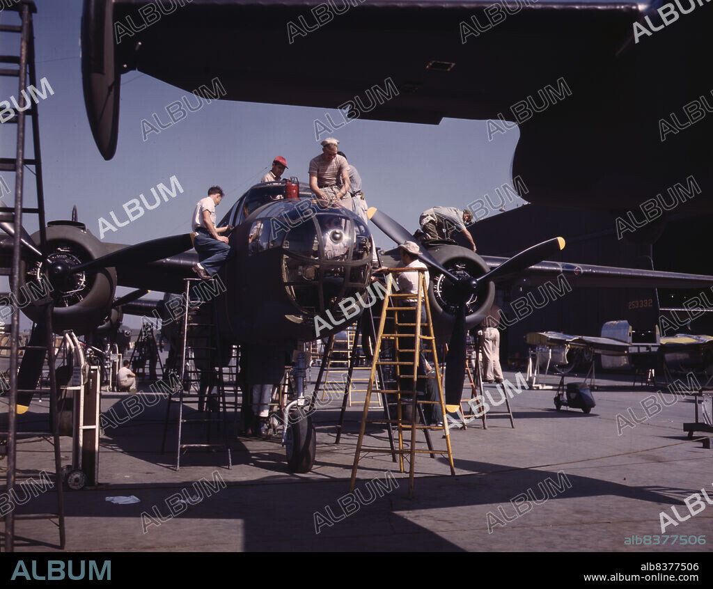 ALFRED T PALMER. Employees on the "Sunshine" assembly line at North American's plant put the finishing touches on another B-25 bomber, Inglewood, Calif. In addition to the battle-tested B-25 ("Billy Mitchell") bomber, used in General Doolittle's raid on Tokyo, this plant produces the P-51 ("Mustang") fighter plane which was first brought into prominence by the British raid on Dieppe.
