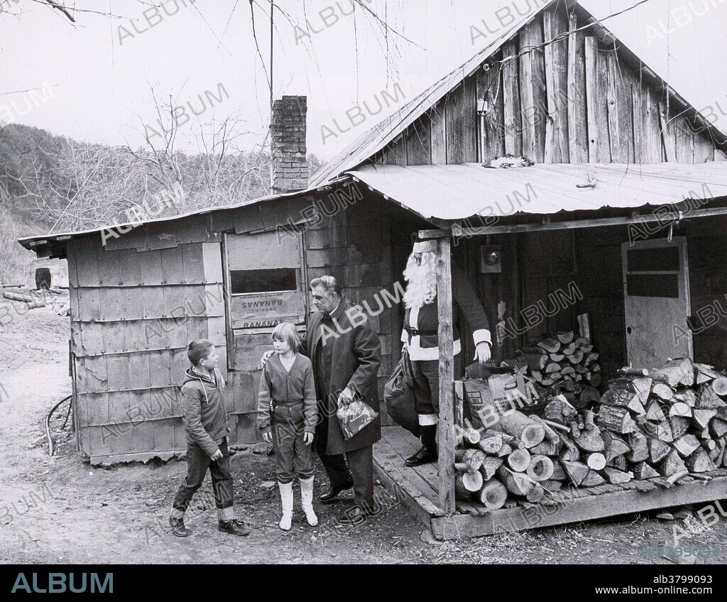 Santa Claus brings presents to children in Appalachia, thanks to the Parson of the Hills; 1965. The charity was set up to provide gifts to the children of the Appalachias. Here, the Parson and Santa give out gifts to two kids outside their home.