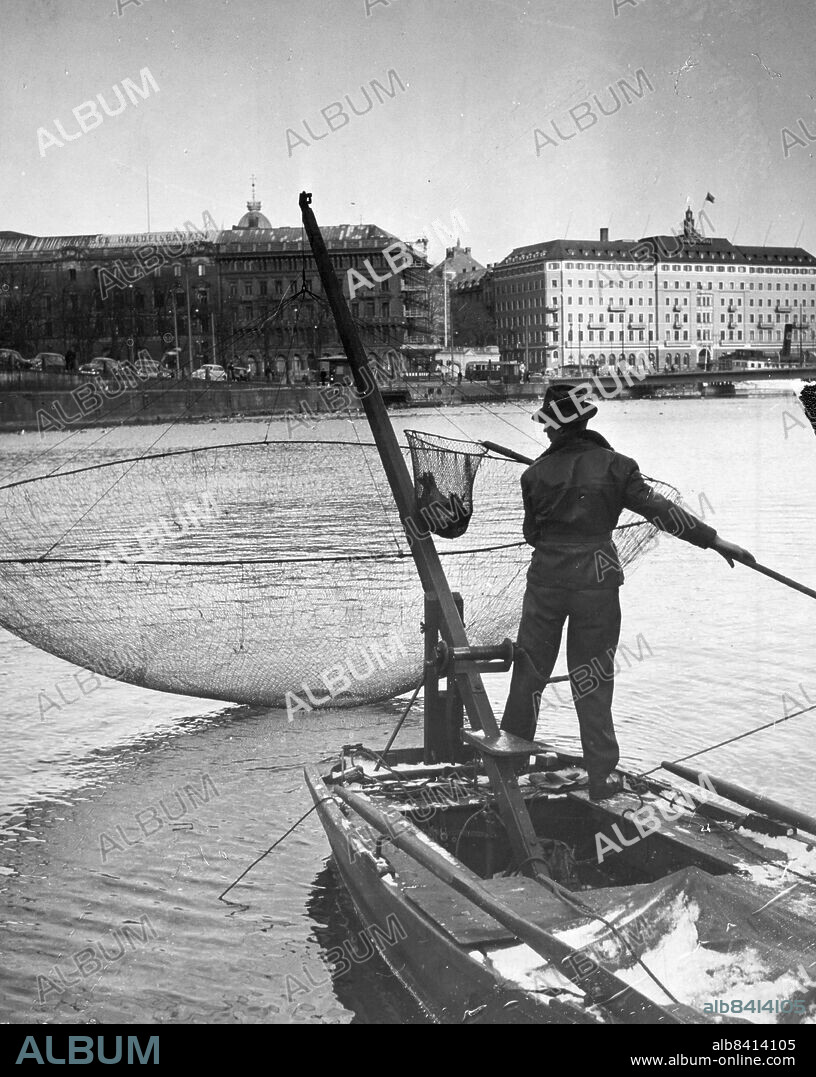 Stockholm 1955-03-18. Fiske Norrström. På fredagen debuterade årets förste norsfiskare i Strömmen. Det var Harald i skinnjacka, yllehalsduk och pjäxor, som förleddes av den glittrande solen. Det första mötet med håven blev dock mera kylslaget än Harald förmodat när han gav sig ut.. Foto: Boris Engström / DN / TT / Kod: 192. ** SvD OUT **.