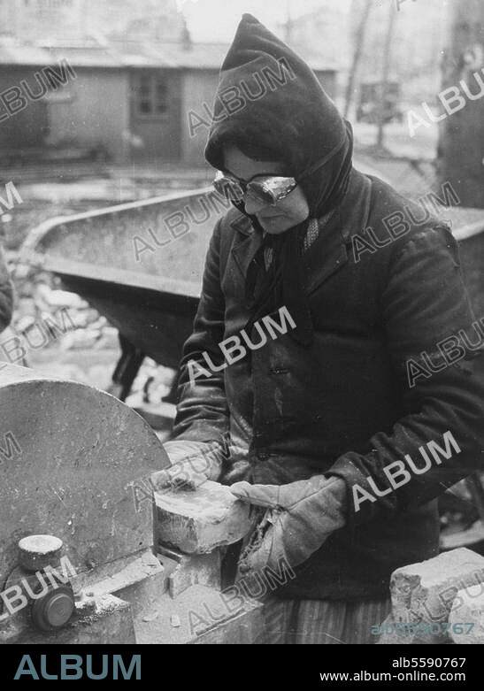 "Trümmerfrauen" in Berlin Dienstverpflichtung von Frauen als Arbeitkräfte für die Beseitigung von Trümmern (Gesetz des Alliierten Kontrollrats vom 14. Januar 1946). "Trümmerfrau" bei Aufbereiten von Ziegeln für die Wiederverwendung. Foto.
