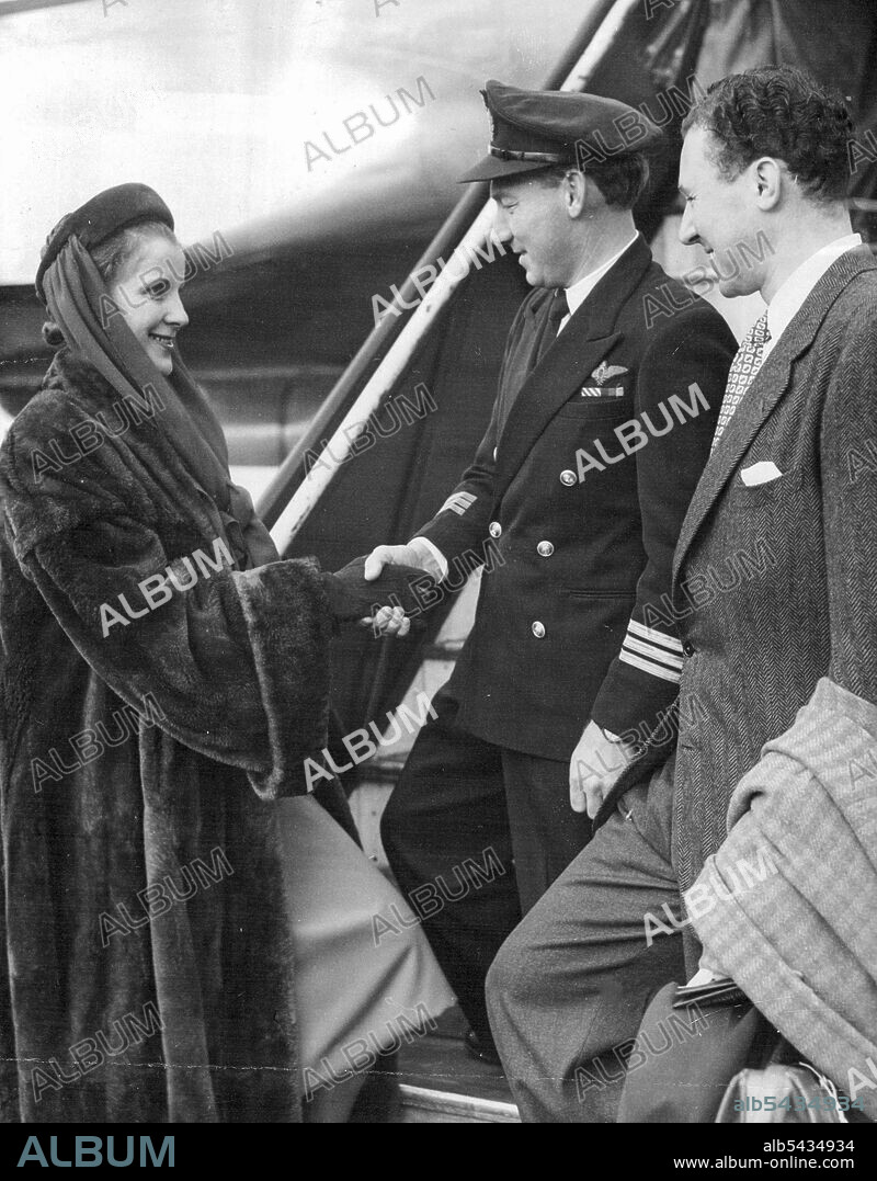 Diana Wynyard Leads Shakespeareans On 14-Weeks Tour Of Australia -- Diana Wynyard the aircraft, Captain R. Uren, at London Airport. At right is Mr. Anthony Quayle the director. Members of the Shakesperian memorial Theater Company of Stratford-on-avon, led by Diana Wynyard and Anthony Quayle, the director, left London Airport by B. O. A. C. - Qunatas airport for a fourteen weeks tour of Australia and New Zealand. The company is believed to be the biggest theatrical company ever to have travelled.