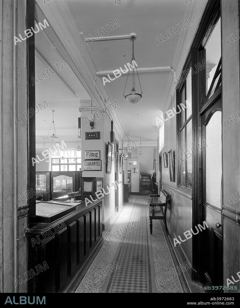 A corridor in the Legal Insurance offices at Thames House in The Strand, London, 1921. Fire insurance is dealt with at the counter on the left, and the cashier's office is further down the corridor.