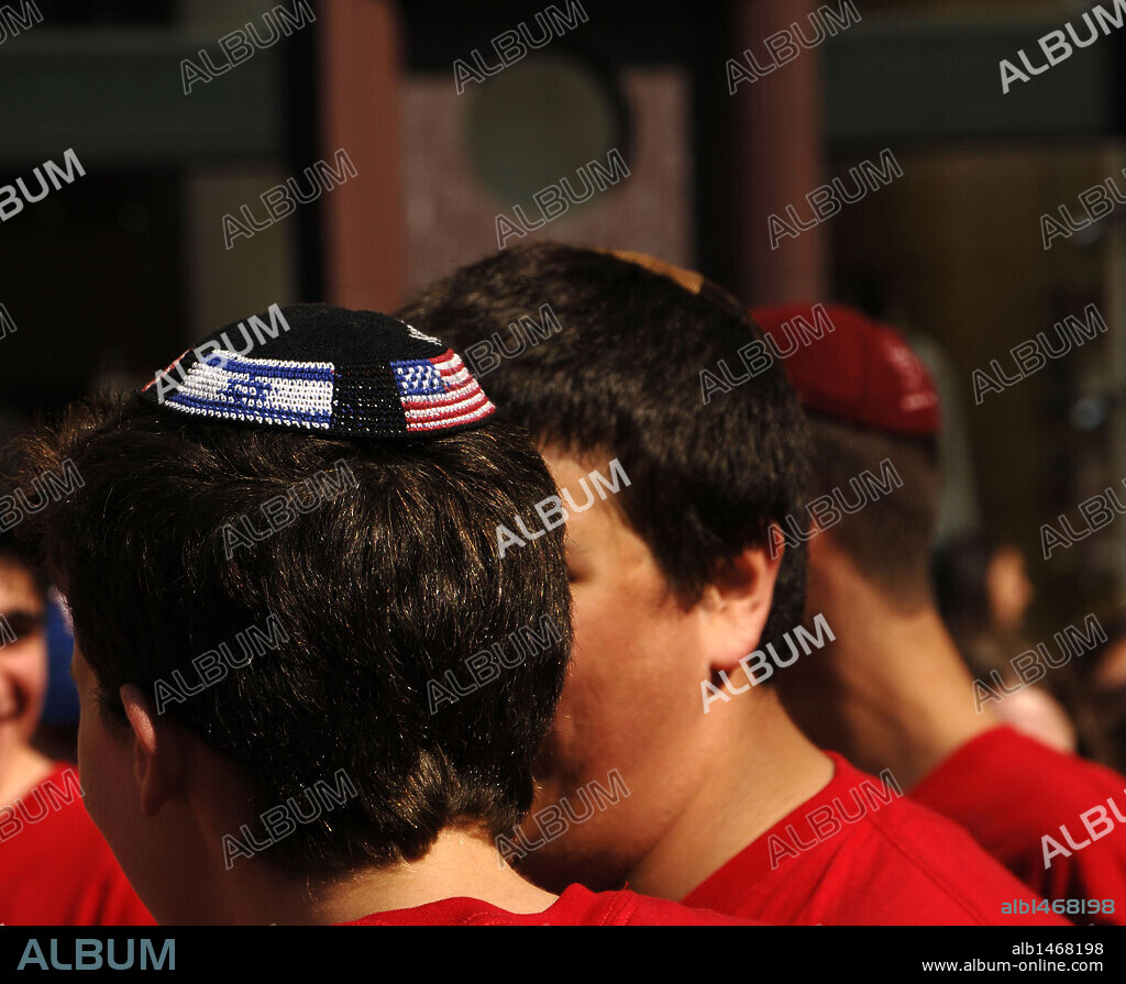 Young jewish with kippah or yarmulke with the American and Israeli flags. New York. United States.