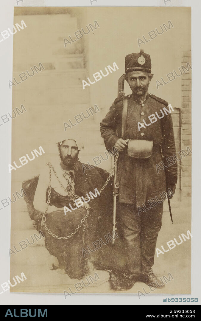 Albumen silver photograph, 19th century, Qajar, Qajar Period, 13 9/16 x 10 1/2 in., 34.4 x 26.7 cm, albumen, chains, gun, Iran, men, Middle Eastern, military, Persian, photograph, photography, portait, sepia, slave, street.