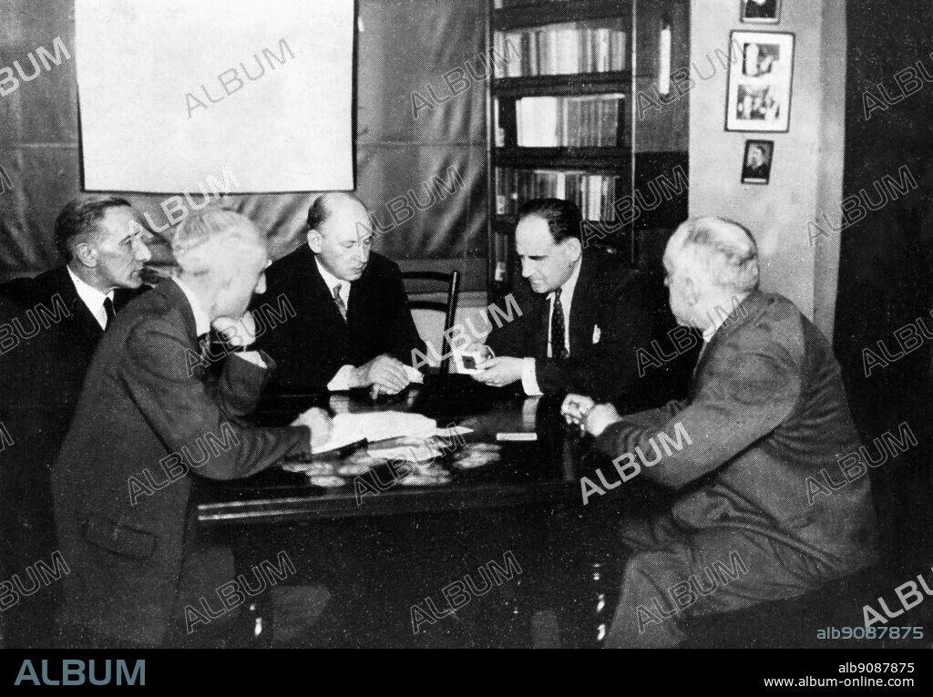 An experiment in telepathy - Dr. Seal (centre) and Harry Price test Fred Marion, who is sensing the value and colour of a playing card from its back. ©TopFoto.
