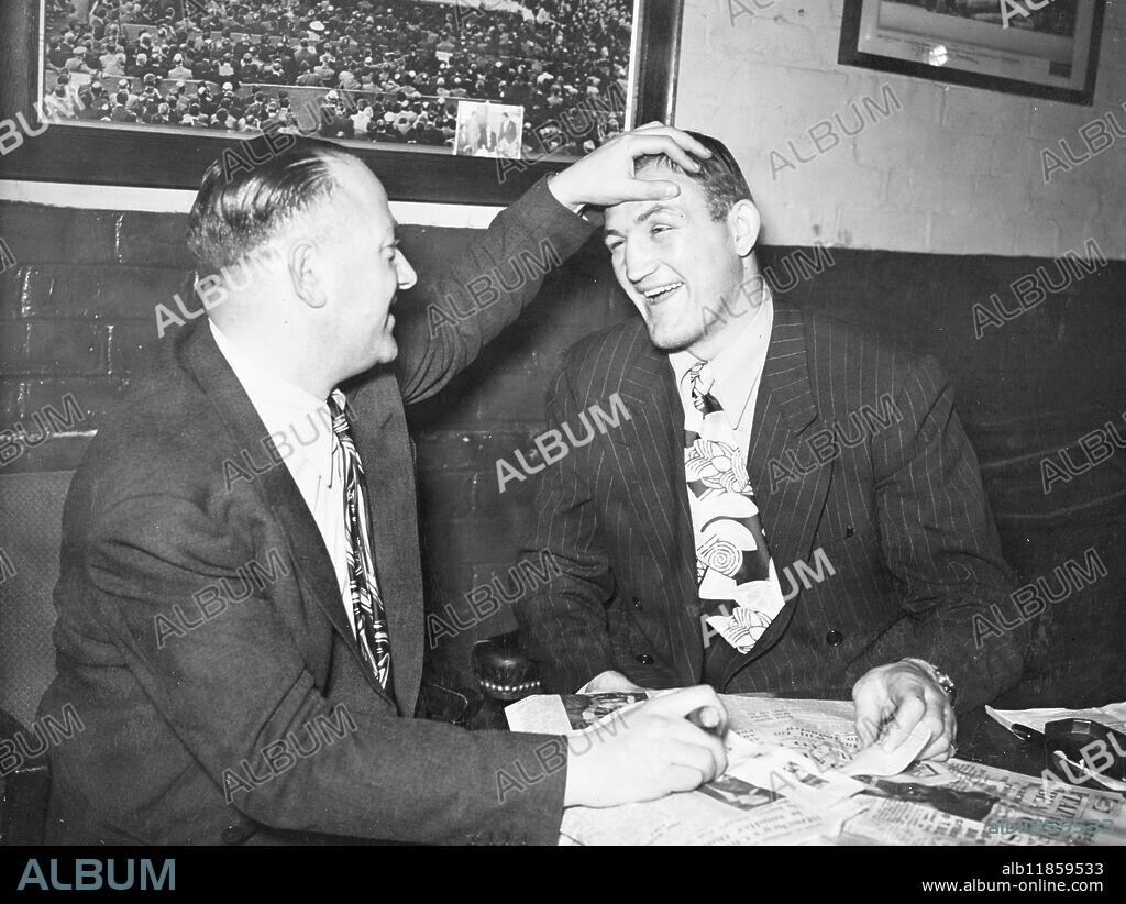 American heavyweight of Pennsylvania Joe Baksi, who beat light-heavyweight champion of Great Britain Freddie Mills of Bournemouth at Haringay Arena did not come through the fight completely unscathed. Here Jack Solomons, the fight promoter has a look at Joe's damaged eye. 6 November 1946.