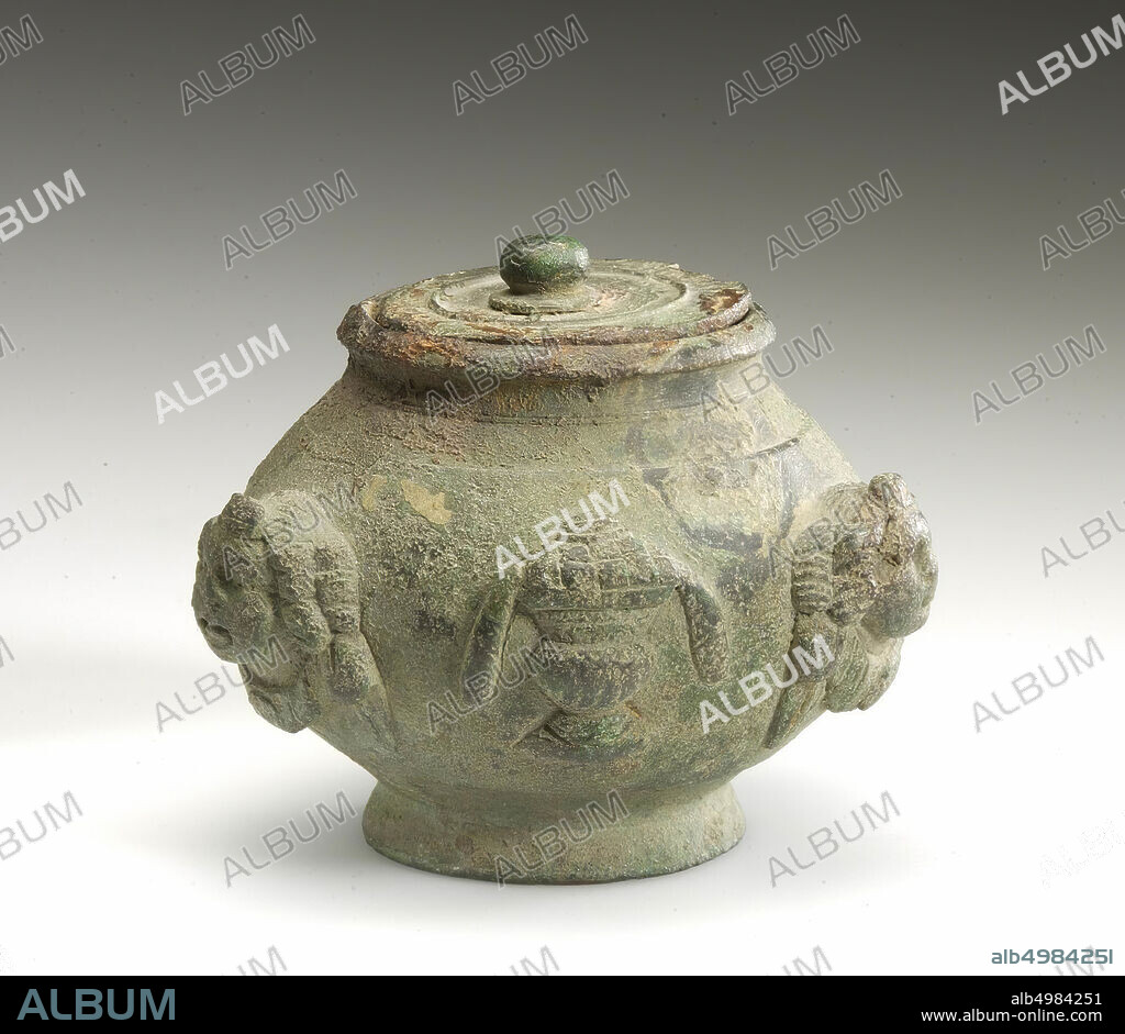 Roman bronze pyxis of type as M.W.5 (from the Wychense plain), but of a smaller size and execution. Probably from the same studio. The handle with eyelets and attaches is missing, as is the lid closure. Made possible in a studio in the Maasvallei. The jar is decorated with women's cups, including garlands in high relief, interspersed with objects. Greenish patina. Rust spots on lid and rim, potty, bath oil jar, metal, bronze, height: 7 cm, roman 100-200 AD, Netherlands, Limburg, Heerlen, Welten.
